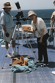 [Marge & Arnold at a telescope on deck]